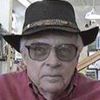 John Franklin Unsmiling older man with a cowboy hat and tinted glasses